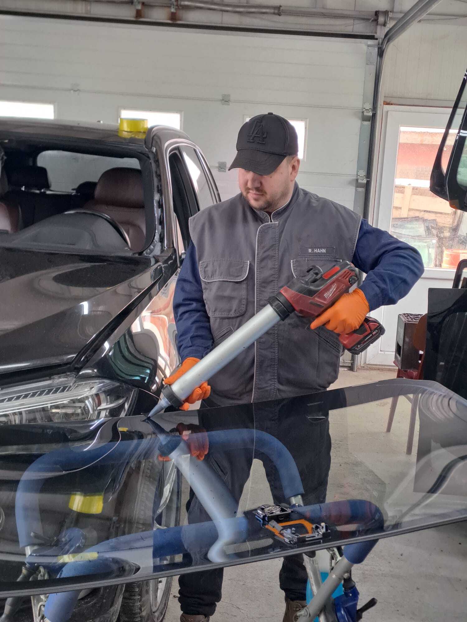 Tehnician care montează un parbriz auto într-un atelier de specialitate